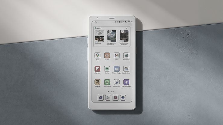 Smartphone mit E-Book-Reader-App auf dem Bildschirm, das auf einer zweifarbigen Oberfläche liegt