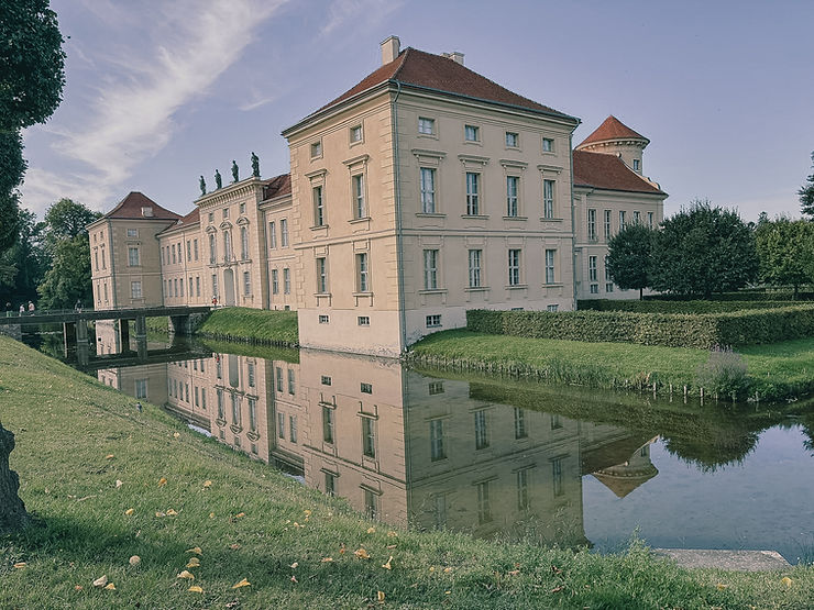 Schloss mit Wassergraben und Brücke, das sich im Wasser spiegelt