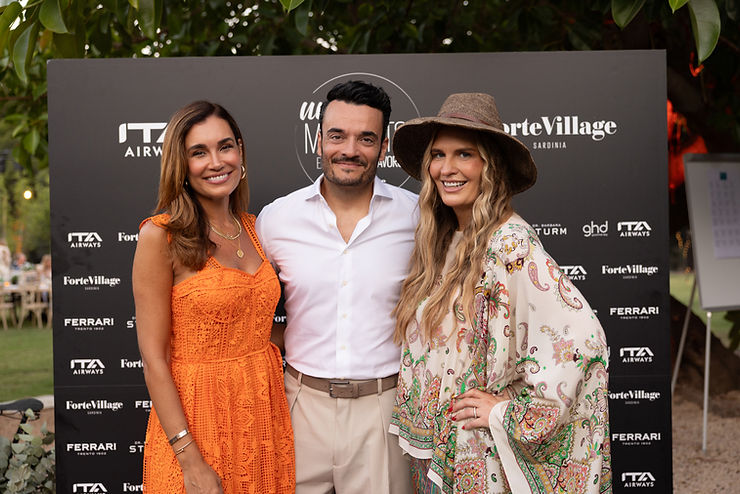 Prof. Dr. h.c. mult. Nike Schröder,  Jana Ina und Giovanni Zarrella stehen vor einer Werbewand, Jana Ina Zarrella trägt ein ärmelloses orangefarbenes Kleid, Nike Schröder einen Hut und ein gemustertes langärmeliges Oberteil, Giovanni Zarrella trägt ein weißes Hemd und eine helle Hose.