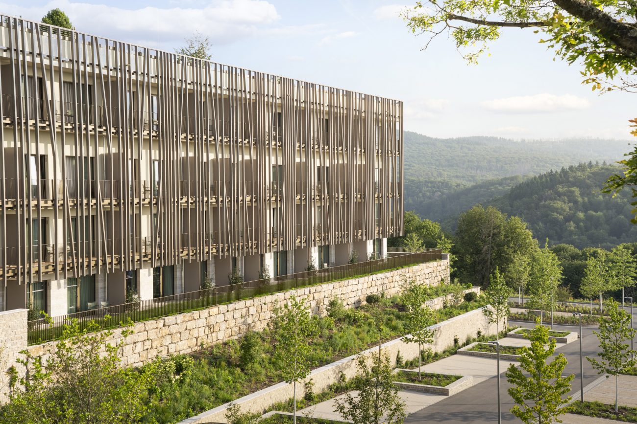 „Wie aus dem Wald gewachsen: Die vertikale Holzlamellenfassade des WALD.WEIT fügt sich in die bewaldete Hügellandschaft des Rheingau-Taunus-Kreises ein."