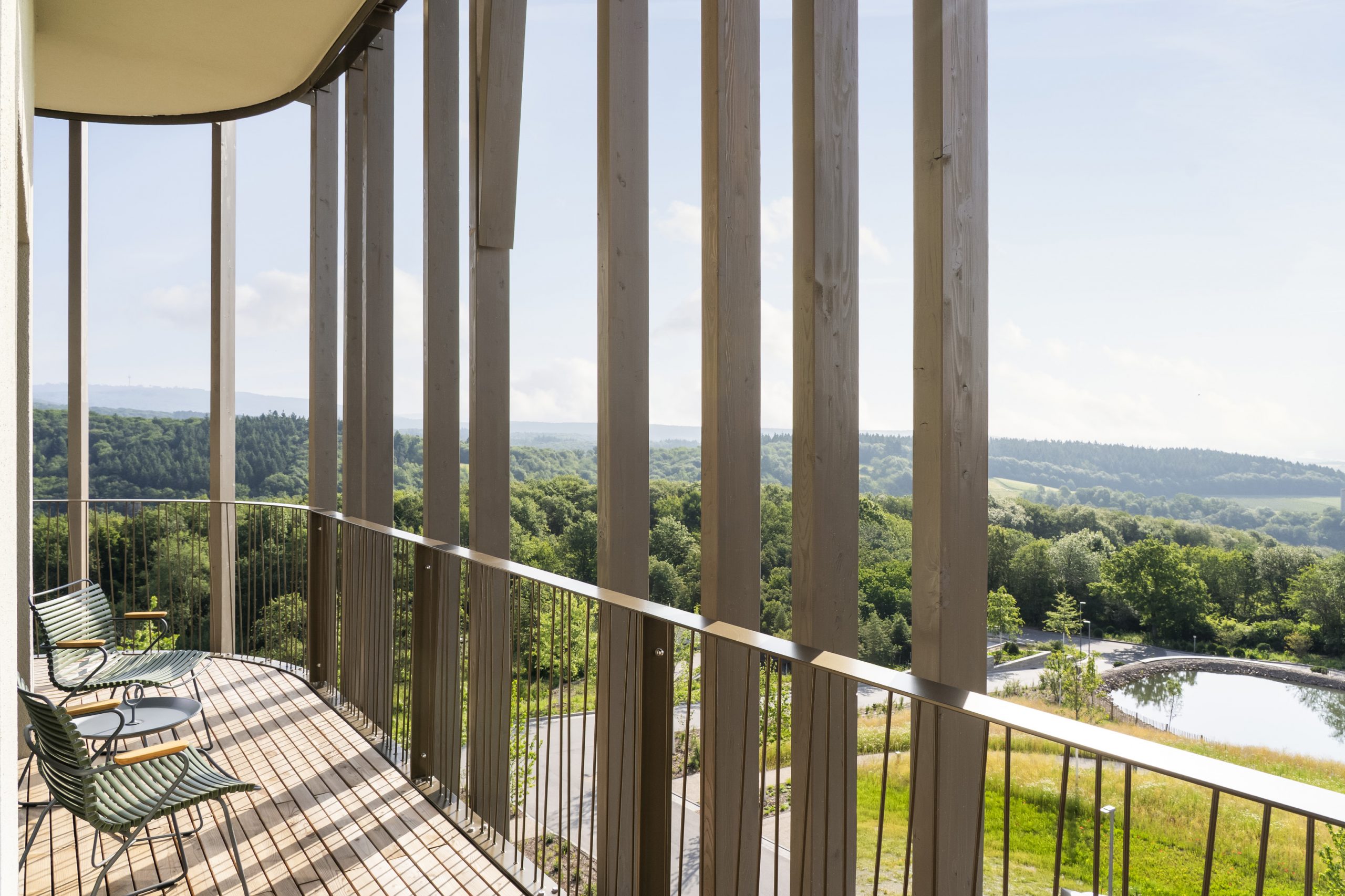 Balkon mit Holzlamellen und Blick über das Waldtal