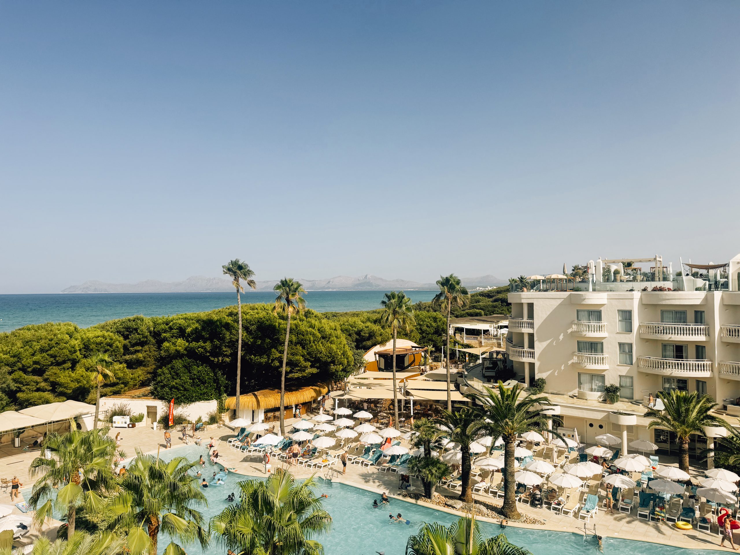 Poolblick mit Meer und Bergen im Hintergrund