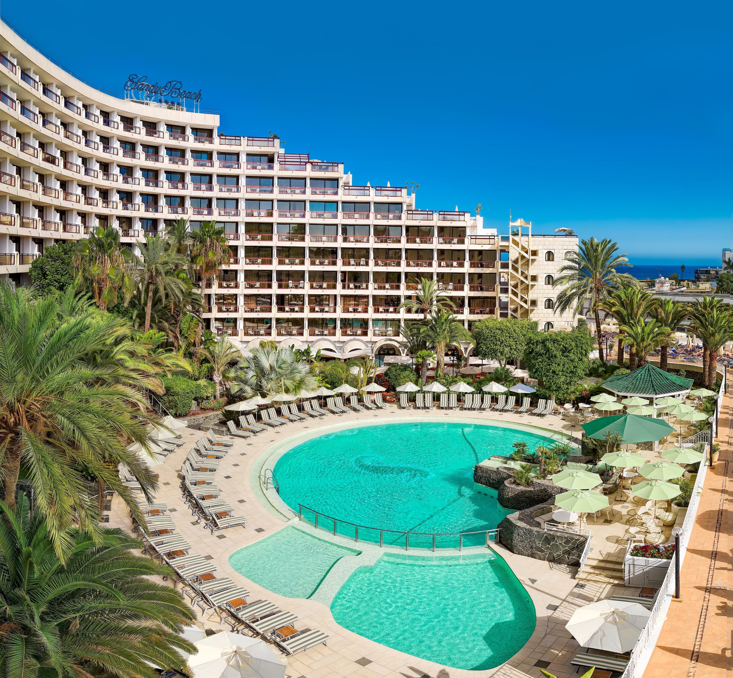 Seaside Sandy Beach Hotel mit arabisch inspirierter Architektur, umgeben von Palmen